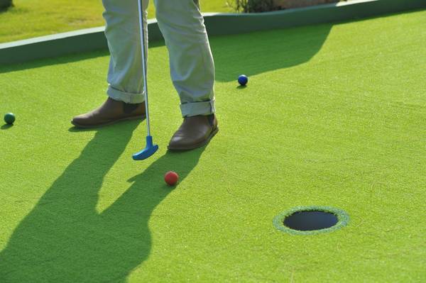 …đánh golf tại sân mini Putt-Putt…