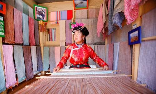 Phụ nữ Mosuo dệt vải trong cửa hàng ở Lệ Giang, Trung Quốc. Ảnh: Chien-min Chung.