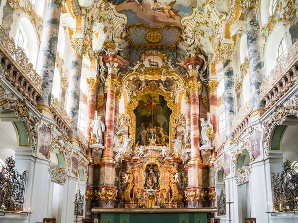Nhà thờ Wieskirche, Steingaden, Đức: Đây là một nhà thờ hình trái xoan, nằm trên một ngọn đồi thấp, dưới chân dãy núi Alpes, được xây dựng từ thế kỉ 18. Nơi đây là một ví dụ điển hình về kiến trúc Rococo Bavarian. Phong cách độc đáo đặc trưng bởi việc sử dụng màu vàng và ánh sáng kết hợp cùng các tác phẩm điêu khắc, trang trí hoa văn và đồ nội thất. Mỗi năm, nhà thờ chào đón hơn một triệu du khách và được Unesco công nhận là Di sản thế giới. Ảnh: NaughtyNut/Shutterstock.