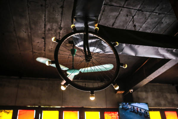 Ở đây bạn còn thấy sự phá cách trong trang trí với bánh xe đạp được biến thành đèn trần nhà độc đáo.