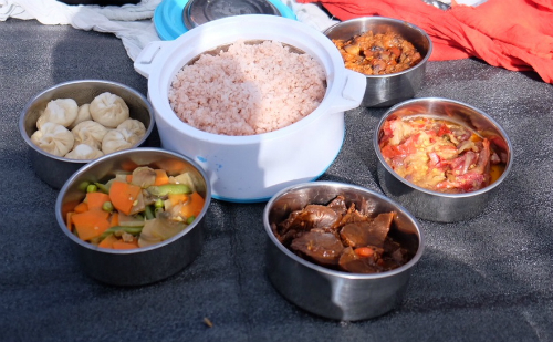 Bữa cơm do lái xe và hướng dẫn viên chuẩn bị cho hai người khách ăn cùng trong một buổi trekking. Cơm nấu từ gạo huyết rồng (red rice), bánh bao, rau củ xào, ớt nấu với phomat và một món thịt.