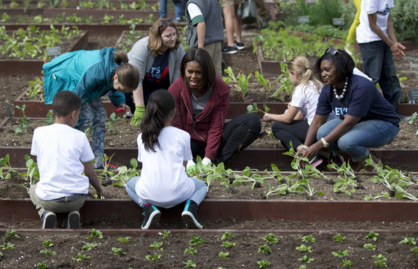 Không chỉ được nghe giải thích về tác dụng của việc ăn rau xanh và chế độ ăn uống tốt cho sức khỏe, các thành viên nhí còn được tự tay xới đấy, gieo hạt hay trồng cây giống cùng phu nhân tổng thống Mỹ. Ảnh: Carolyn Kaster/AP.