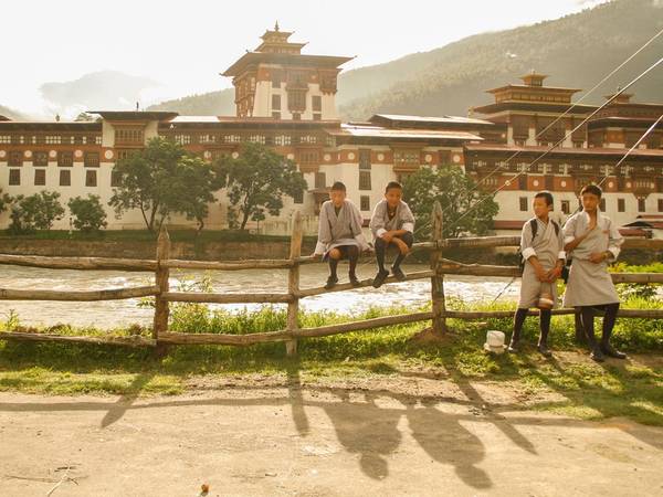 Học sinh ở thị trấn Punukha đang chờ xe bus trước dzong - một kiểu pháo đài kiêm tu viện ở Bhutan. Quốc gia này có khoảng 18 dzong đang hoạt động, dưới vai trò tôn giáo và trung tâm hành chính.