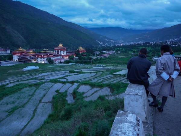 Người dân địa phương ngắm nhìn Tashichho Dzong ở Thimphu vào buổi tối. Được xây dựng năm 1216, khu tổ hợp đền đài, công trình hành chính này là trung tâm quyền lực của Bhutan.