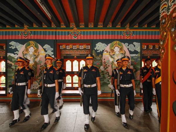 Những người lính sau lễ hạ cờ ở Tashichho Dzong, trung tâm quyền lực của chính phủ Bhutan. Quốc gia này có nền quân chủ chuyên chế tới năm 2008, sau đó chính phủ chuyển sang quân chủ lập hiến.