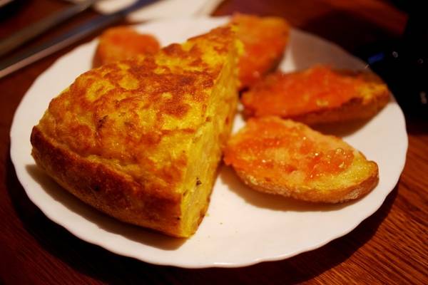 Omlette kiểu Tây Ban Nha được gọi là Tortilla Española, dùng khoai tây và trứng là nguyên liệu chính. Món này thường ăn kèm với những lát bánh mì nướng giòn đã phết sốt cà chua thơm ngon. Ảnh: Hương Chi.