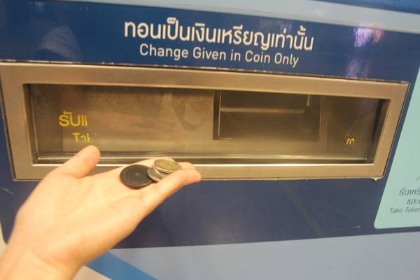 Nhận lại tiền thối và thẻ đi tàu điện ngầm ở khe phía dưới máy. Ảnh: San San