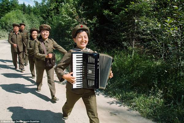 Một nhóm lính mặc đồng phục chơi nhạc trong lúc diễu hành qua vùng nông thôn ở Triều Tiên