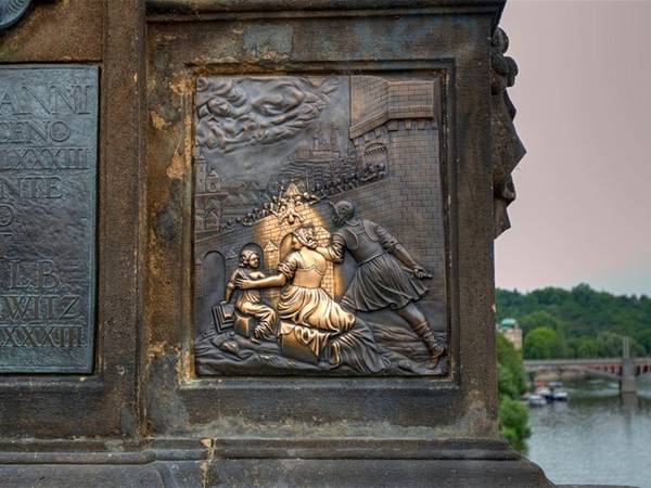 Chạm vào bức tượng thánh John xứ Napomuk cũng đảm bảo cho bạn cơ hội thăm lại Prague, thủ đô Cộng hòa Czech. Phía dưới bức tượng mô tả cảnh thánh John bị ném khỏi cây cầu.