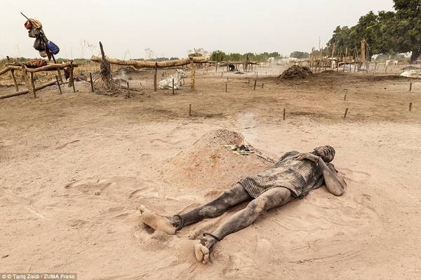 Người đàn ông này thư giãn trên lớp tro mềm mịn cạnh đống lửa phân bò đã gần tàn. Loại tro này mịn như bột talcum, bảo vệ cả người và bò khỏi cái nóng như thiêu như đốt của Sudan.