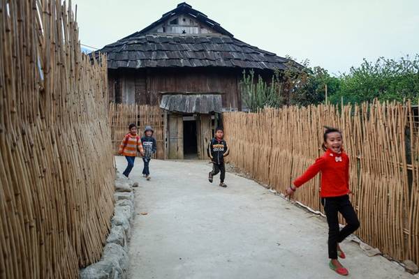 Trẻ con ở bản đi học qua những cánh cổng làm bằng gỗ pơmu, tường rào làm bằng tre độc đáo.