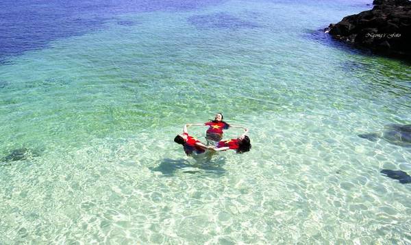 Du khách thỏa sức chơi đùa dưới làn nước biển trong xanh ở cù lao Bờ Bãi. Ảnh: Ngong Hankang