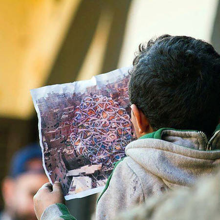 Một cậu bé trong khu phố chăm chú xem diện mạo tương lai của phố rác trên bản vẽ - Ảnh: streetartnews