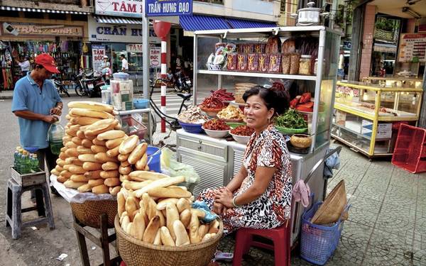 Thưởng thức ẩm thực đường phố Việt Nam: Từ những người bán rong gánh hàng trên vai, tới xe đẩy, quầy ăn ở chợ hay trên vỉa hè, ẩm thực đường phố Việt Nam sẽ đem lại cho du khách những trải nghiệm khó quên. Ảnh: Roughguides.