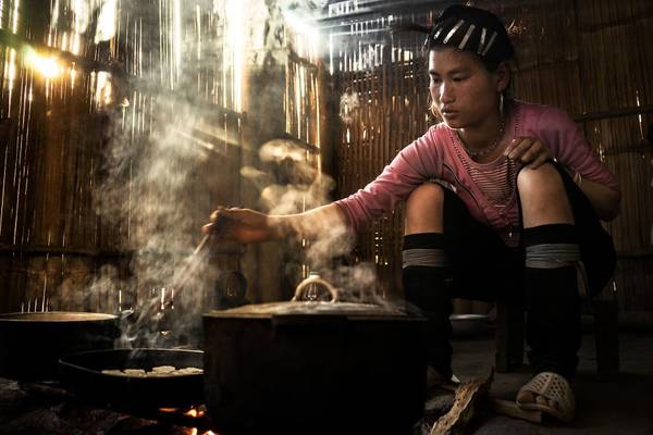 Một thiếu nữ dân tộc ở Sapa nấu cơm trong ánh nắng chiếu qua vách. König cho biết những món ăn ở đây rất ngon.