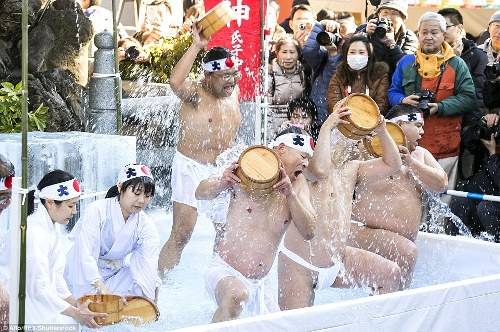Cũng tại Tokyo, ở đền Teppozu Inari Shinto, nhiều du khách và người dân địa phương đang vây quanh bể tắm để theo dõi nghi lễ này.
