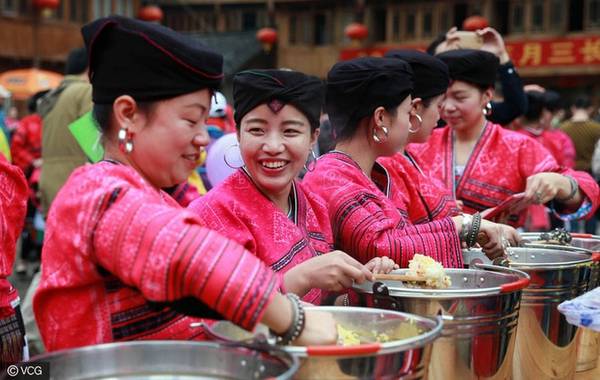 Phụ nữ Dao Đỏ ở Quế Lâm, khu tự trị Quảng Châu, tây nam Trung Quốc có truyền thống tổ chức lễ hội tóc dài vào ngày 3/3 âm lịch hàng năm. Họ có mái tóc dài từ 1,5 đến 2,3 mét và chỉ cắt duy nhất một lần trong đời. Trong hình là những phụ nữ đang nấu cơm nếp để đón du khách mùa lễ hội hôm 9/4 vừa qua. Ảnh: VCG.