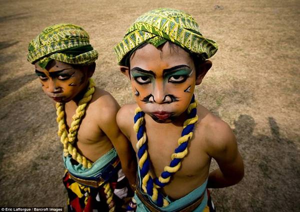 Hai cậu bé mặc quần áo với các phụ kiện cầu kỳ và vẽ mặt trong Lễ hội Borobudur, đảo Java, Indonesia.