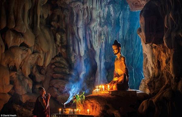 Nhà sư đang cầu nguyện bên bức tượng hoàng tử Siddhartha nổi tiếng trong giai đoạn khổ luyện của mình bên trong một hang động cổ 500 triệu năm.