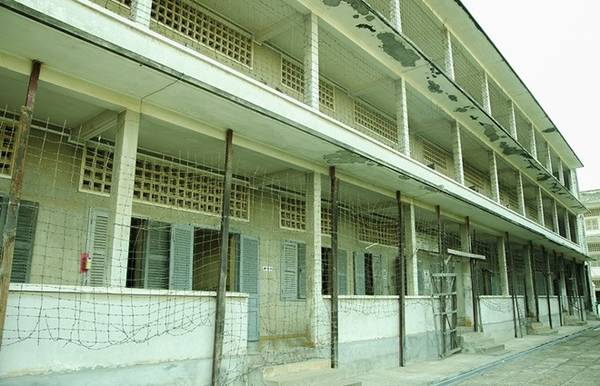 Dãy lớp học tại Tuol Sleng được bao bọc bởi hàng rào dây thép gai.