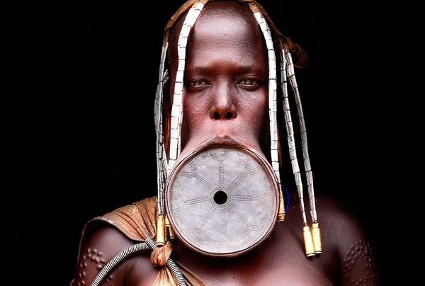 Khi một thành viên nữ của bộ tộc tới tuổi trưởng thành, cô sẽ phải nhổ bỏ hai răng cửa ở hàm dưới, trước khi cắt một lỗ nhỏ ở môi dưới. Một chiếc đĩa gốm nhỏ được lồng vào lỗ này. Kích cỡ đĩa tăng dần, kéo dãn vành môi ra.