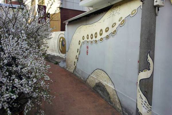 Làng Tranh Haeung-dong là khu dân cư tương đối phát triển của Suwon. Cộng đồng họa sĩ graffiti trong và ngoài Hàn Quốc đã trang hoàng lại những ngõ hẻm như mê cung ở đây. Các tác phẩm khéo léo kết hợp sự vật hiện hữu, như đường ống nước, dây diện... vào chủ đề. Bạn không nên bỏ qua bức tranh bạch tuộc dài 10 m, với những chiếc vòi kéo dài cả ngõ, các nét vẽ thanh mảnh kiểu châu Á, hay tranh vẽ gia đình hươu cao cổ... Một số địa điểm tham quan khác trong làng bao gồm triển lãm Alternative Art Space Noon, Space Bom, hay Bom Cafe chuyên mặt hàng trà truyền thống và sản phẩm thủ công. Ảnh: Trent Holden/Lonly Planet.