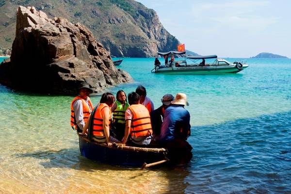 Để ra được thuyền, du khách phải lên những chiếc thúng hoặc phà tự chế để ngư dân dầm mình trong nước kéo ra thuyền nằm cách 100 m. Ảnh: Nhi Nguyễn.