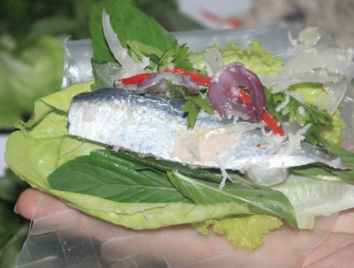 Gỏi cá trích được ăn kèm với bánh tráng, các loại rau sống và chén nước chấm đậm đà.