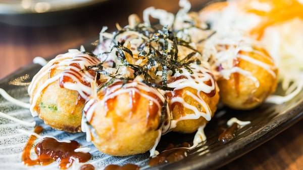Nhật Bản: Takoyaki là món ăn vỉa hè được yêu thích, gồm các viên bạch tuộc nướng rưới sốt ngọt, rong biển và cá khô bào. Mùi thơm của takoyaki khiến du khách khó lòng từ chối. Ảnh: Eater.