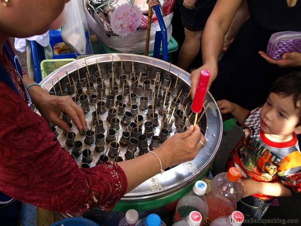 Kem que: Khác với hình ảnh của xe kem cây rải dài khắp Việt Nam, món quà vặt này tại Chatuchak được bán trong những chiếc xe đặc biệt, với những lỗ sâu, nhỏ đựng kem. Khi có khách mua, người bán kéo thanh tre bên trên là cả cây kem sẽ hiện ra. Bạn có thể tìm thấy mọi loại hương vị trong món kem này, từ mirinda, coke đến trà sữa Thái. Mỗi cây kem có giá 4 baht. Ảnh: Hawkebackpacking.