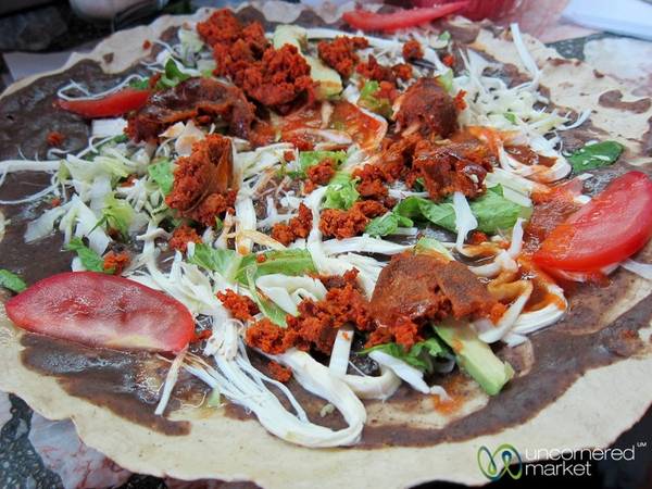 Mexico: Vùng Oaxaca của Mexico nổi tiếng với nền ẩm thực phong phú và độc đáo. Một trong các món ăn được nhiều du khách yêu thích là tlayuda - bánh mì dẹt với một lát thịt lợn thái mỏng, đậu chiên, khoai tây, bơ và một số loại thịt khác xé nhỏ. Ảnh: Uncornered Market.