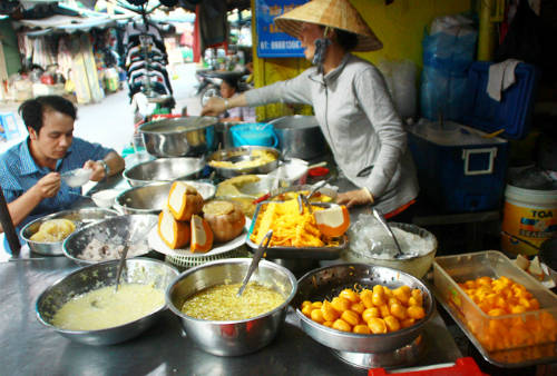 Sạp chè Campuchia hấp dẫn với màu sắc vàng ươm của bí đỏ, bánh trứng, mì trứng, bánh hoa... Ảnh: Đức Thành