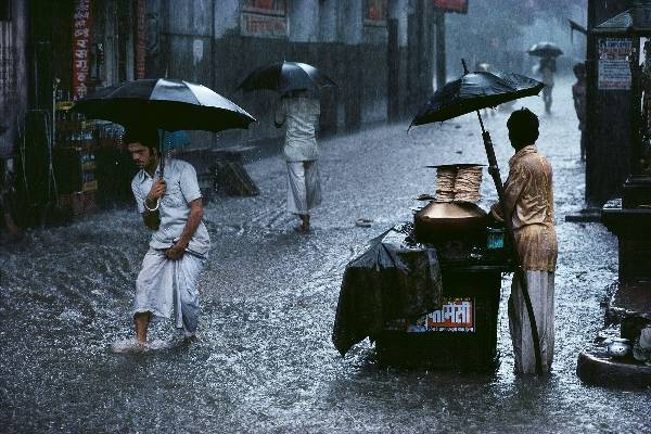 Mặc mưa gió, người đàn ông vẫn kiên trì bán bánh trên đường phố Chandni Chowk, Old Delhi, Ấn Độ