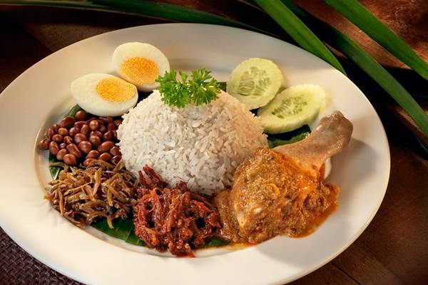 Nasi lemak: Đây được coi là món ăn biểu trưng của Malaysia với nguyên liệu phong phú và cách trình bày đẹp mắt. Cơm nấu cốt dừa được cho lên lá chuối xanh, rưới sốt sambal cay, cá trống khô, lạc rang, dưa chuột, trứng (luộc hoặc ốp la), đôi thi có thêm thịt gà hoặc hải sản. Ảnh: Touristic360.