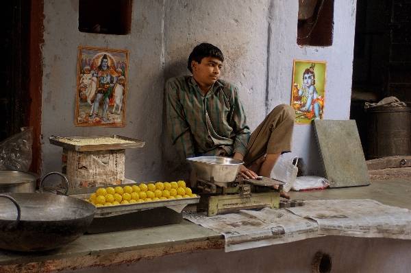 Chàng thanh niên trẻ trầm ngâm bên quầy bánh của mình trên phố phường Ấn Độ