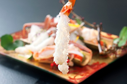 Đầu bếp làm sashimi cua tuyết bằng cách lột bỏ lớp vỏ chân rồi ngâm phần thịt vào nước đá 10 phút. Thịt cua xòe ra trông như chùm lá thông. Khi ăn thực khách có thể chấm với tương và thưởng thức vị ngon ngọt nguyên bản của thịt cua. Ảnh: Guide Michelin.