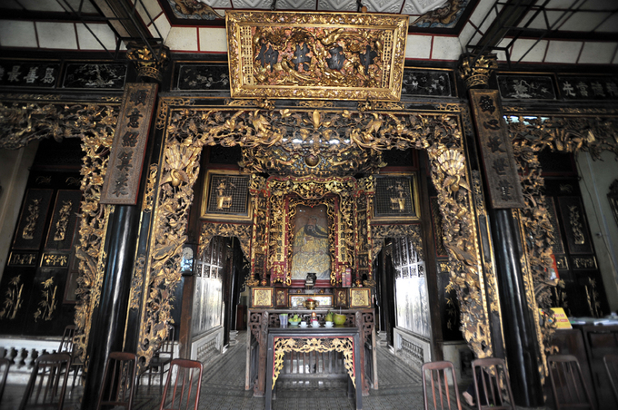 Nội thất căn nhà cổ mang đậm màu sắc Trung Hoa với cánh cửa, cột nhà, bàn thờ... sơn son thếp vàng, chạm trổ loan phượng rất sắc sảo và tinh tế. Chính giữa là ban thờ Quan Công, một vị tướng thời Tam Quốc.
