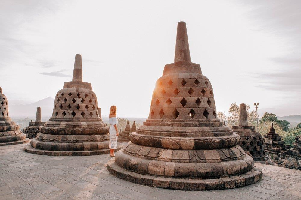Đối lập với màn đêm huyền bí ở Prambanan là khung cảnh bình minh thơ mộng ở Borobudur - ngôi đền Phật giáo lớn nhất thế giới. Hành trình leo 100 bậc thang dốc đứng để lên tới đỉnh đền khi mặt trời chưa ló rạng, cùng chi phí khoảng 450.000 Rupiah (hơn 700.000 đồng), sẽ được đền đáp xứng đáng khi bạn đứng giữa những bức phù điêu cổ kính, tôn nghiêm, lấp lánh nắng vàng. Ảnh: Lissa Kahayon.