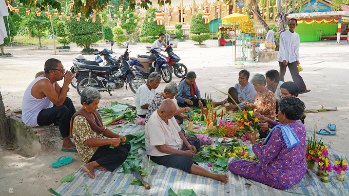 Theo nghi thức truyền thống của người Khmer, cứ đến lễ hội hoặc dịp đặc biệt, người dân và Phật tử sẽ cùng đến chùa để chuẩn bị. Trong ảnh là hoạt động làm hoa thủ công từ bắp chuối để trang trí trong lễ khánh thành gian nhà mới của chùa.