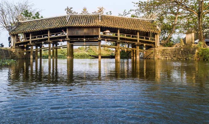 Cầu ngói Thanh Toàn Cầu ngói Thanh Toàn nằm ở làng Thanh Thủy Chánh, xã Thủy Thanh, thị xã Hương Thủy. Công trình này làm bằng gỗ, kiến trúc theo kiểu "thượng gia, hạ kiều", tức trên nhà dưới cầu, dài hơn 18 m, rộng gần 6 m. Đây là một trong số ít cây cầu với kiểu kiến trúc này còn tồn tại đến ngày nay ở Việt Nam. Cây cầu cách trung tâm thành phố chừng 8 km. Bạn có thể đi trước để dành thời gian chiều nghỉ ngơi ở thôn Vĩ Dạ. Ảnh: Thanh Toàn.