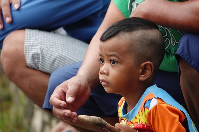 Cậu bé Khmer theo cha mẹ đi xem hội đua bò.
