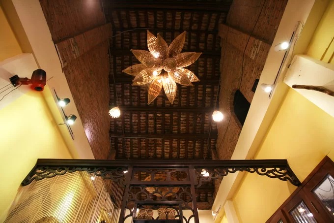 Chiếc đèn chùm bằng tre treo trên trần nhà, mái lợp ngói âm dương vẫn được giữ nguyên của ngôi nhà cổ.
