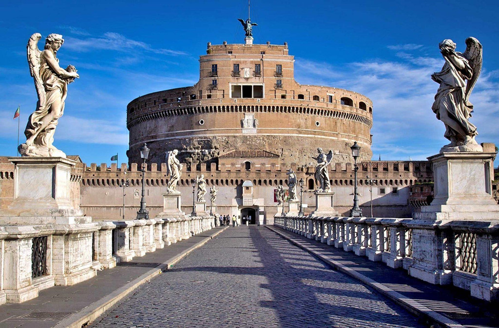 Lâu đài Sant''Angelo: Đến Vatican, bạn nhất định phải ghé thăm lâu đài San’tAngelo sừng sững bên dòng sông Tiber thơ mộng. Tòa lâu đài được xây dựng bởi kiến trúc sư Antonius Pius. Trước đây, công trình được sử dụng làm nhà tù quốc gia. Khi du lịch Vatican phát triển, nơi đây lại trở thành điểm tham quan hấp dẫn. Cây cầu Ponte San’tAngelo được bắc qua sông Tiber ngay phía trước tòa lâu đài khiến khung cảnh nơi đây càng thơ mộng, nhất là lúc hoàng hôn buông xuống. Ảnh: Delightfully Italy.