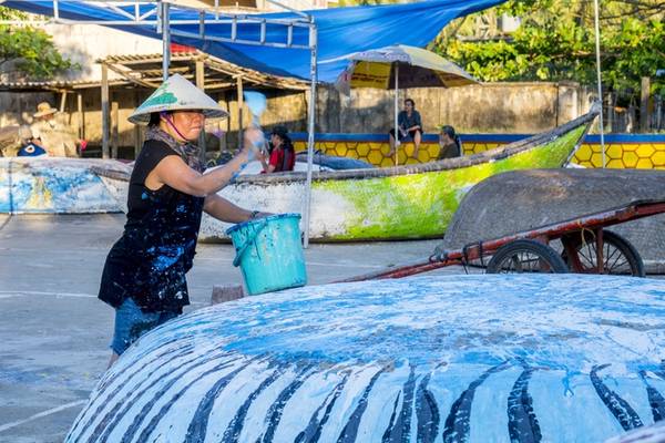 Trên ảnh là họa sĩ Trần Thị Thu đang thực hiện tác phẩm của mình trên mặt thúng. Trong số 111 thuyền thúng, có 89 thúng tròn có đường kính 1 đến 3 m, 22 thuyền (thúng méo) 4,5 m đến 7 m.