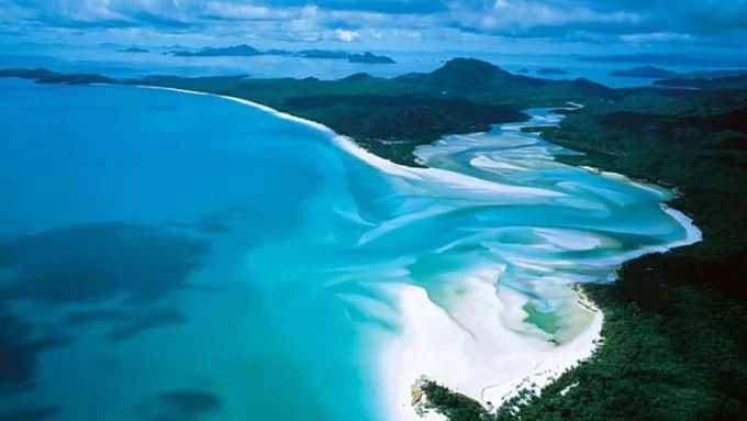 Whitehaven: Nơi cát mềm nhất Trải dài 7 km dọc theo đảo Whitehaven ở vùng Great Barrier, bãi biển này gồm 98% cát silica tinh khiết, loại cát trắng và mềm mại. Điều đặc biệt nữa là cát ở đây không hề nóng, dù khí hậu Queensland khắc nghiệt. Du khách có thể đến đây bằng thuyền, dành cả ngày đi bộ trên cát mềm, hoặc lặn trong làn nước biển xanh như ngọc, ngồi thư giãn và nhấm nháp rượu sâm banh dưới hàng phi lao. Ảnh: CNN.