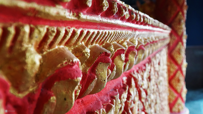 Bao quanh tượng Phật là những chi tiết chạm trổ sắc sảo với màu sắc sặc sỡ.