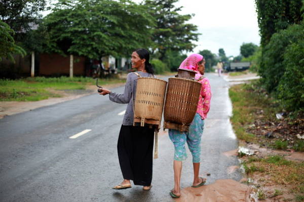  Hai người đàn bà Êđê cầm tẩu thuốc, gùi rau trên quốc lộ 27 đi Đà Lạt sau chiều mưa - Ảnh: TIẾN THÀNH