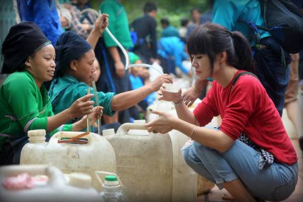 Không chỉ chụp ảnh ruộng lúa, du khách còn có thể tham gia vào nhiều trải nghiệm khác như đi chợ vùng cao. Đông vui nhất có lẽ là cửa hàng bán rượu. Những can rượu ngô, sắn được bày bán rất nhiều. Người bán hồn nhiên mời thử rượu. Ngon, "ưng cái bụng thì mua", không thì thôi, không một lời phàn nàn, không nghĩ suy, tính toán. Ảnh: Nguyễn Ngọc Xuân.