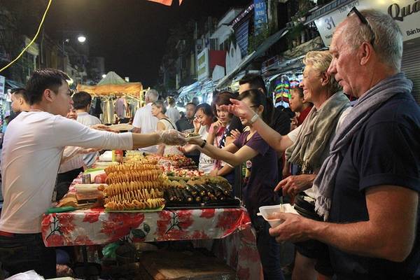 Chợ đêm phố cổ Hà Nội Chợ đêm phố cổ mở vào 3 ngày cuối tuần, từ 18h đến 23h, là điểm đến quen thuộc với nhiều du khách đến Hà Nội. Các mặt hàng ở chợ đa dạng, đẹp mắt. Đầu phố Hàng Đào là một dãy hàng ăn vặt với các loại hoa quả như dứa, mận, xoài, cóc... dầm chua ngọt, màu sắc hấp dẫn. Đi sâu vào trong phố Hàng Đào, Hàng Ngang đến Hàng Giấy là các gian bán sản phẩm lưu niệm, quần áo, giầy dép với đủ kích cỡ, màu sắc. Trong đó, các quầy đồ thủ công mỹ nghệ luôn nhận được sự quan tâm của du khách nước ngoài. Thời điểm đông vui nhất vào khoảng 20h-22h. Điều thuận tiện cho du khách là phiên chợ chỉ dành cho người đi bộ, không có các phương tiện như ô tô, xe máy cản trở. Ảnh: Võ Tuyết.