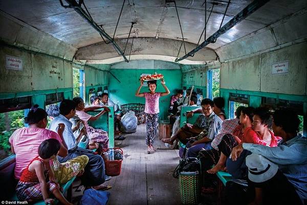 Một cô bé đang bán dưa hấu trên chuyến tàu di chuyển vòng quanh thành phố Yangon. Tất cả các chuyến tàu cũ này hiện đang dần được thay thế.